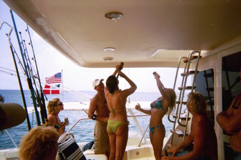 1993 Ford Bronco - A group of people are gathered on the deck of a boat, with fishing rods visible and flags flying in the background.