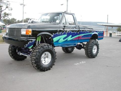 1994 Ford Bronco - This heavily modified pickup truck features a custom paint job and an elevated suspension system with oversized tires.