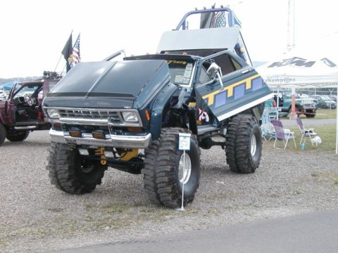 1994 Ford Bronco - Modified pickup truck with oversized tires and custom graphics on display at an outdoor event.