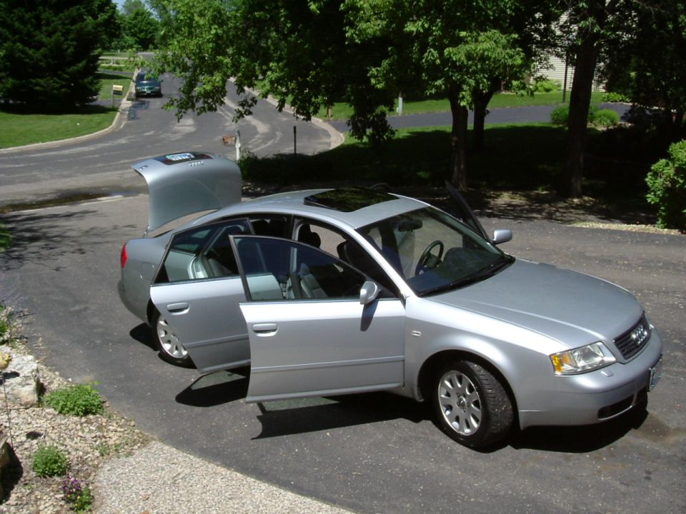 Silver Audi A6 sedan with all doors and trunk open in a driveway