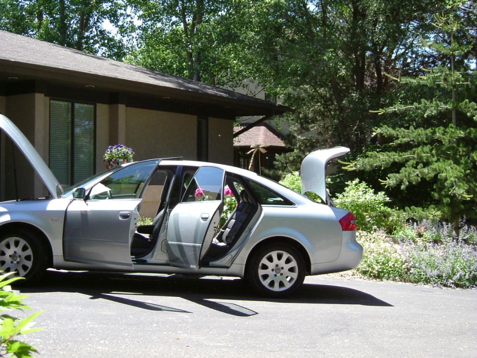 Silver Audi sedan with all doors, hood and trunk open in a driveway