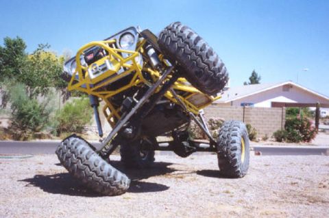 1978 Ford Bronco - A heavily modified off-road vehicle is captured at an unusual angle, revealing its custom suspension and roll cage.