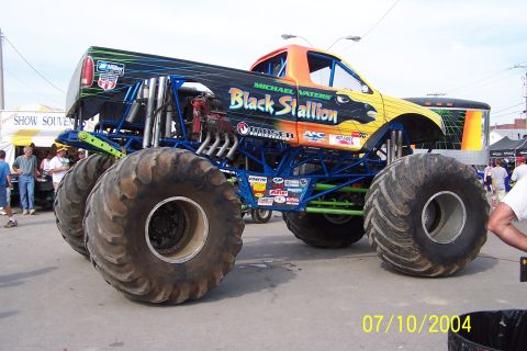 1979 Ford Bronco - The 'Black Stallion' monster truck features a custom paint job and oversized tires, indicating it's built for off-road competition.