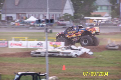 1979 Ford Bronco - A monster truck event features a Bigfoot truck airborne over demolished vehicles.