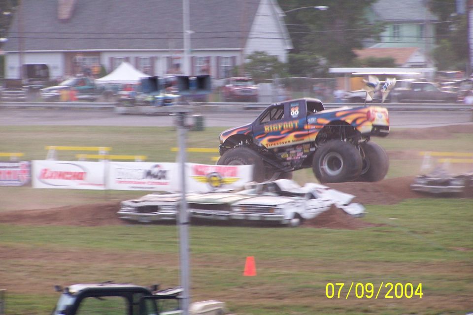 Monster truck named Bigfoot jumps over wrecked cars in a dirt arena