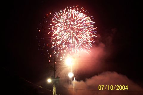 1979 Ford Bronco - A bright fireworks display illuminates the night sky, with smoke and streetlights visible below.