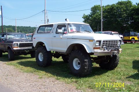 1979 Ford Bronco - A white lifted 1978 Ford Bronco is parked next to a black Ford Bronco.