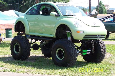 1979 Ford Bronco - A modified Volkswagen Beetle with a lifted suspension and oversized tires is displayed outdoors.