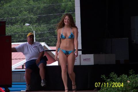 1979 Ford Bronco - A woman models a bikini on a stage, with a man seated to the side. The image is dated July 11, 2004.