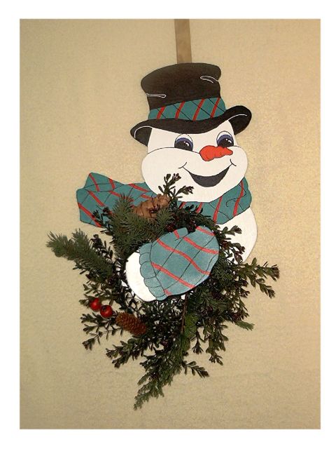 1979 Ford Bronco - A festive snowman decoration, complete with a plaid scarf and hat, is adorned with pine branches and pinecones.