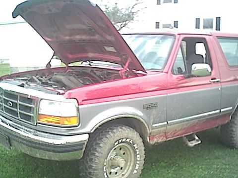 1994 Ford Bronco - This two-tone Ford Bronco has its hood up, revealing the engine compartment.