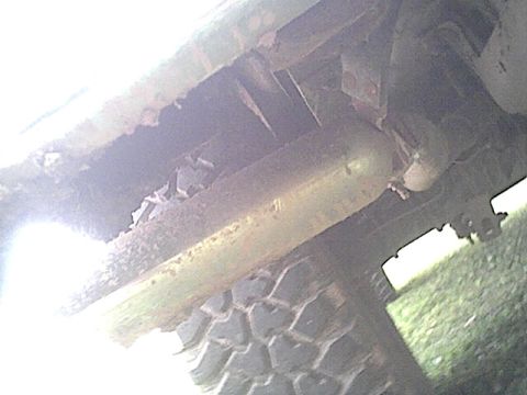 1994 Ford Bronco - Close-up of the undercarriage, revealing the exhaust system and a portion of the tire.