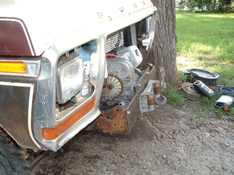 1979 Ford Bronco - Front end of a 1979 Ford Bronco with a winch installed, showing the grille and headlight area.