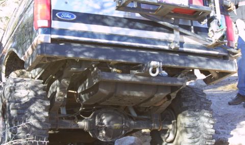 1994 Ford Bronco - The rear axle and suspension of a 1994 Ford Bronco are visible, equipped with large off-road tires.