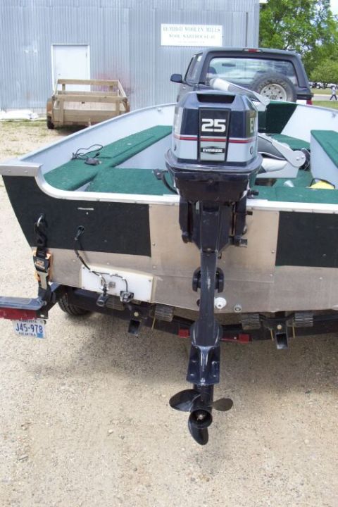 1996 Ford Bronco - A boat with an Evinrude 25 outboard motor is parked on a trailer, with a truck visible in the background.