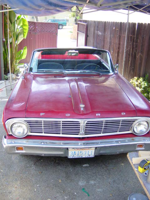 1965 Ford Ranchero - Front view of a red 1965 Ford Ranchero convertible parked under a canopy.