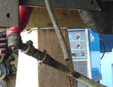 1993 Ford Bronco - Close-up of a vehicle part with a welding machine in the background.