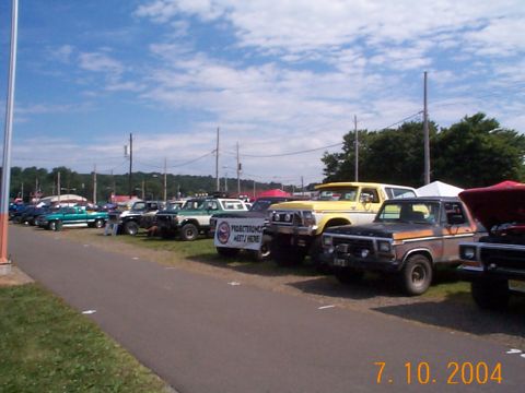 1978 Ford Bronco - Several vehicles, including a 1978 Ford Bronco, are parked in a row under a sunny sky.