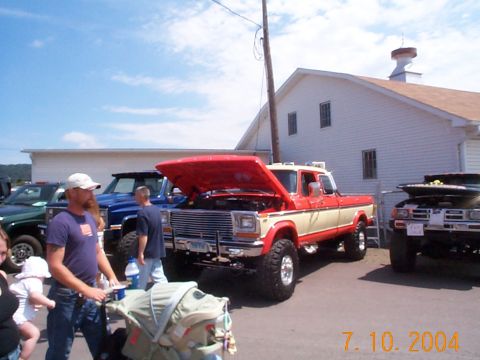 1978 Ford Bronco - A 1978 Ford Bronco pickup truck is displayed with its hood open at an outdoor event.