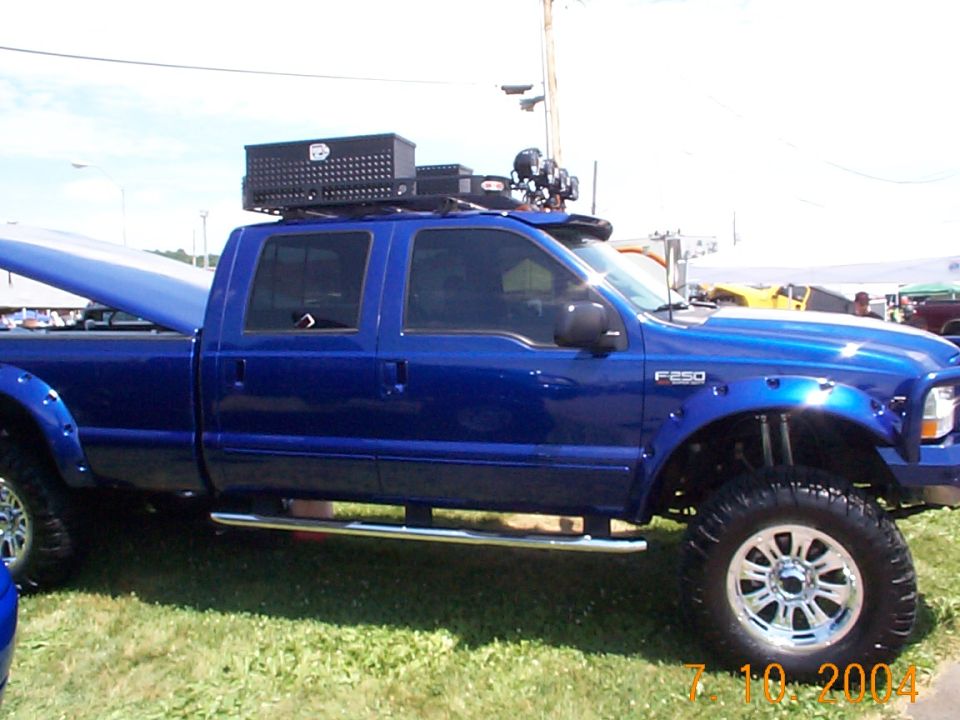 Blue crew cab pickup truck with roof rack and toolbox