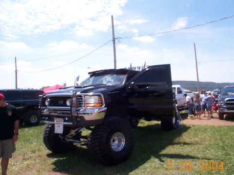 1978 Ford Bronco - This lifted black Ford F-250 Super Duty truck has its doors open at an outdoor event.