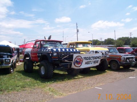 1978 Ford Bronco - A lifted 1978 Ford Bronco with patriotic paint is parked alongside other vehicles.