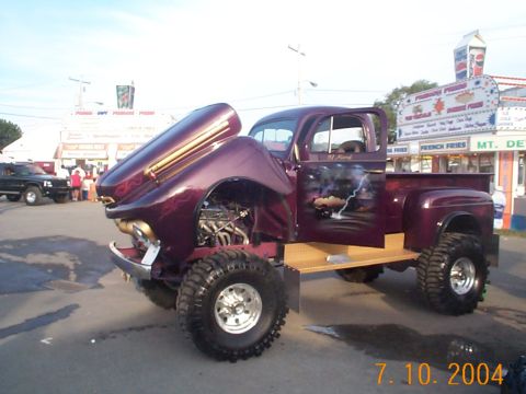 1978 Ford Bronco - A heavily modified purple pickup truck is displayed with its hood open, custom paintwork on the door.