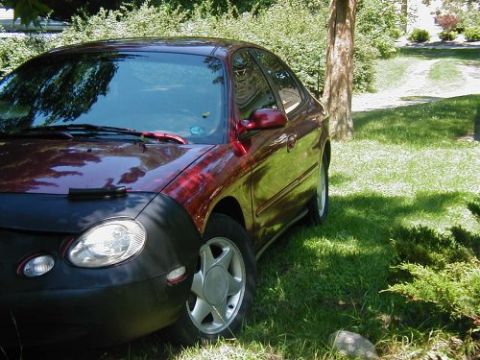 1997 Ford Taurus - A red sedan is parked on a grassy lawn with a tree nearby. The front fender is covered.