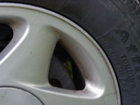 1997 Ford Taurus - A close-up view of a vehicle's wheel and tire, showing some dirt accumulation on the rim.