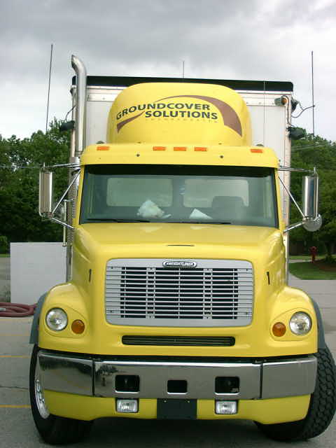 1998 Ford Ranger - Front view of a yellow semi-truck with "Groundcover Solutions" text on its sleeper. The truck has a chrome bumper and grille.