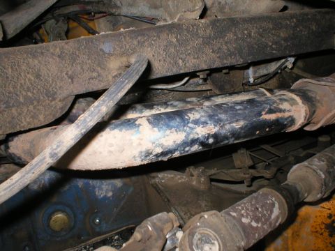 1978 Ford Bronco - Close-up view of the dirty undercarriage of a vehicle, showing various mechanical components.