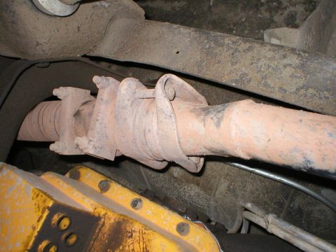 1978 Ford Bronco - Underside view of a vehicle's driveshaft and a yellow component, showing rust and wear.