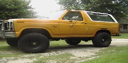 1986 Ford Bronco - This 1986 Ford Bronco is shown in a side profile, oversized tires and a yellow exterior.