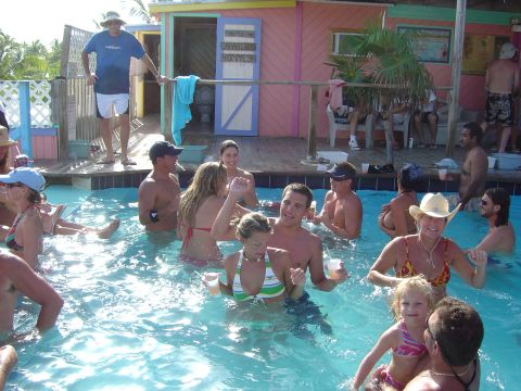 1993 Ford Bronco - A lively scene unfolds at a tropical bar with patrons enjoying the pool and drinks.