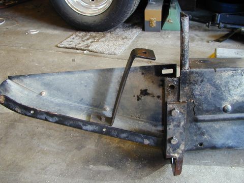 1979 Ford Bronco - A metal bracket is bolted to a section of a dark gray bumper, with a tire visible in the background.