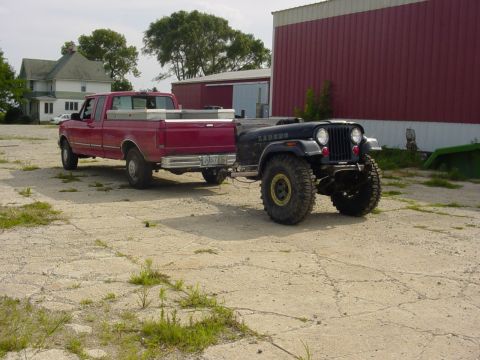 1992 Ford Bronco - Red Ford pickup truck tows a heavily modified black Jeep CJ-7 Laredo.