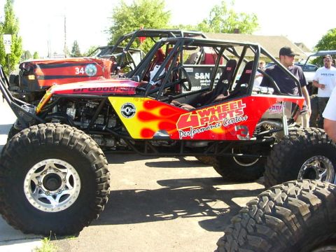 1990 Ford Bronco - This custom off-road buggy features flame graphics and "4 Wheel Parts Performance Centers" branding.