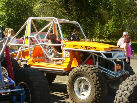 1990 Ford Bronco - A heavily modified off-road buggy with a custom roll cage and large tires is parked outdoors.
