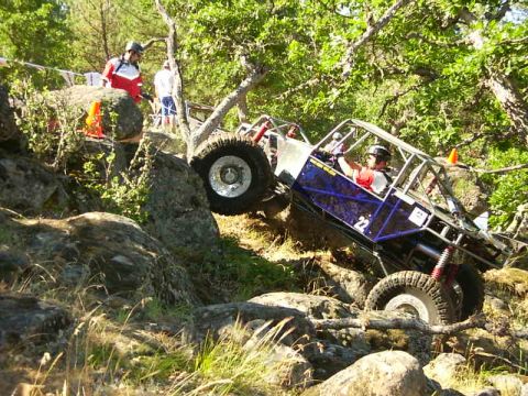 1990 Ford Bronco - A custom off-road buggy navigates a steep, rocky incline during a competition.