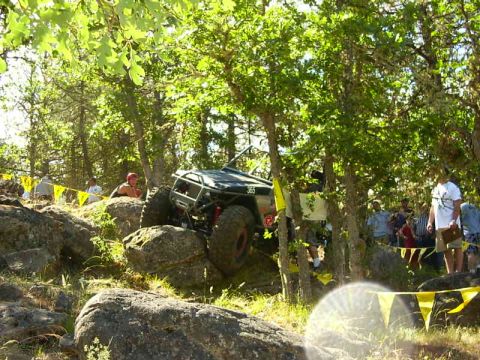 1990 Ford Bronco - A modified off-road vehicle navigates a challenging rocky terrain during an event.
