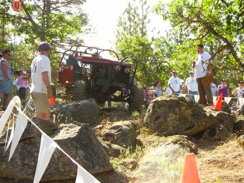 1990 Ford Bronco - An off-road buggy tackles a challenging rocky course during an event, with onlookers observing the action.
