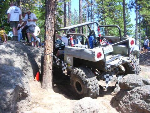 1990 Ford Bronco - Off-road buggy tackles a challenging rocky obstacle course during an event.