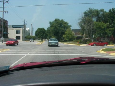 1997 Ford Taurus - Several cars are visible on a street with buildings and trees in the background.