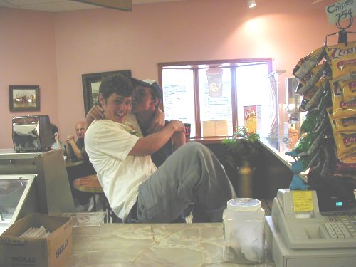 guy holding another guy in a store, chips on display