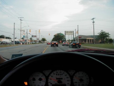 1997 Ford Taurus - View from inside a car shows a road with traffic and a Sears Auto Center in the background.