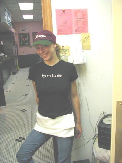 1997 Ford Taurus - A woman wearing a black t-shirt with 'bebe' printed on it and a baseball cap smiles for the camera.