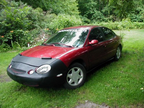 1997 Ford Taurus sedan with a black car bra parked on grass
