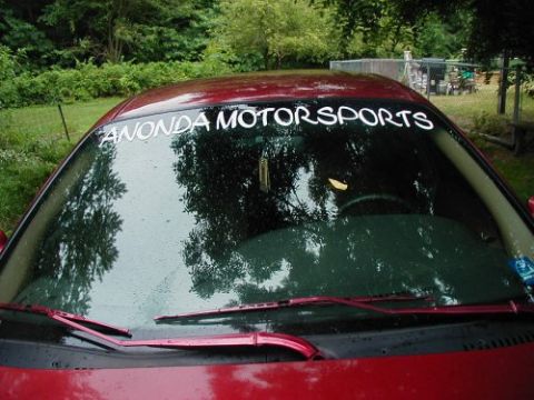 1997 Ford Taurus - Windshield banner on a red car, with reflections of trees and a Supermotors logo.