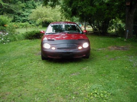 1997 Ford Taurus - Front view of a 1997 Ford Taurus parked on a grassy lawn, fitted with a car bra.