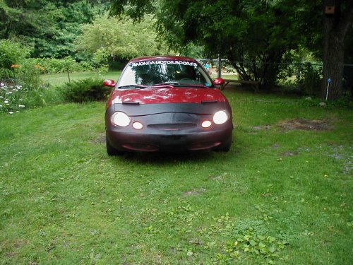 1997 Ford Taurus front view with car bra and 'HONDA MOTORSPORTS' banner on windshield